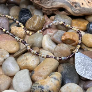 Handcrafted Bohemian necklace featuring black and berry purple Czech Picasso glass seed beads with an antique silver pendant.